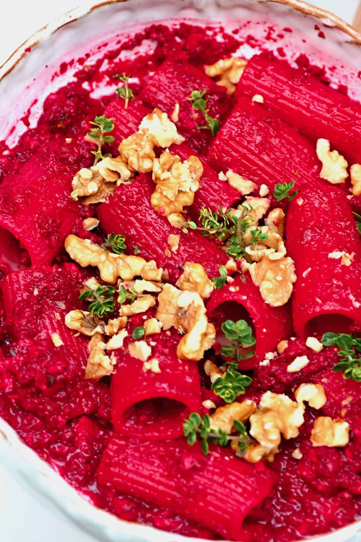 Beetroot pasta topped with walnuts