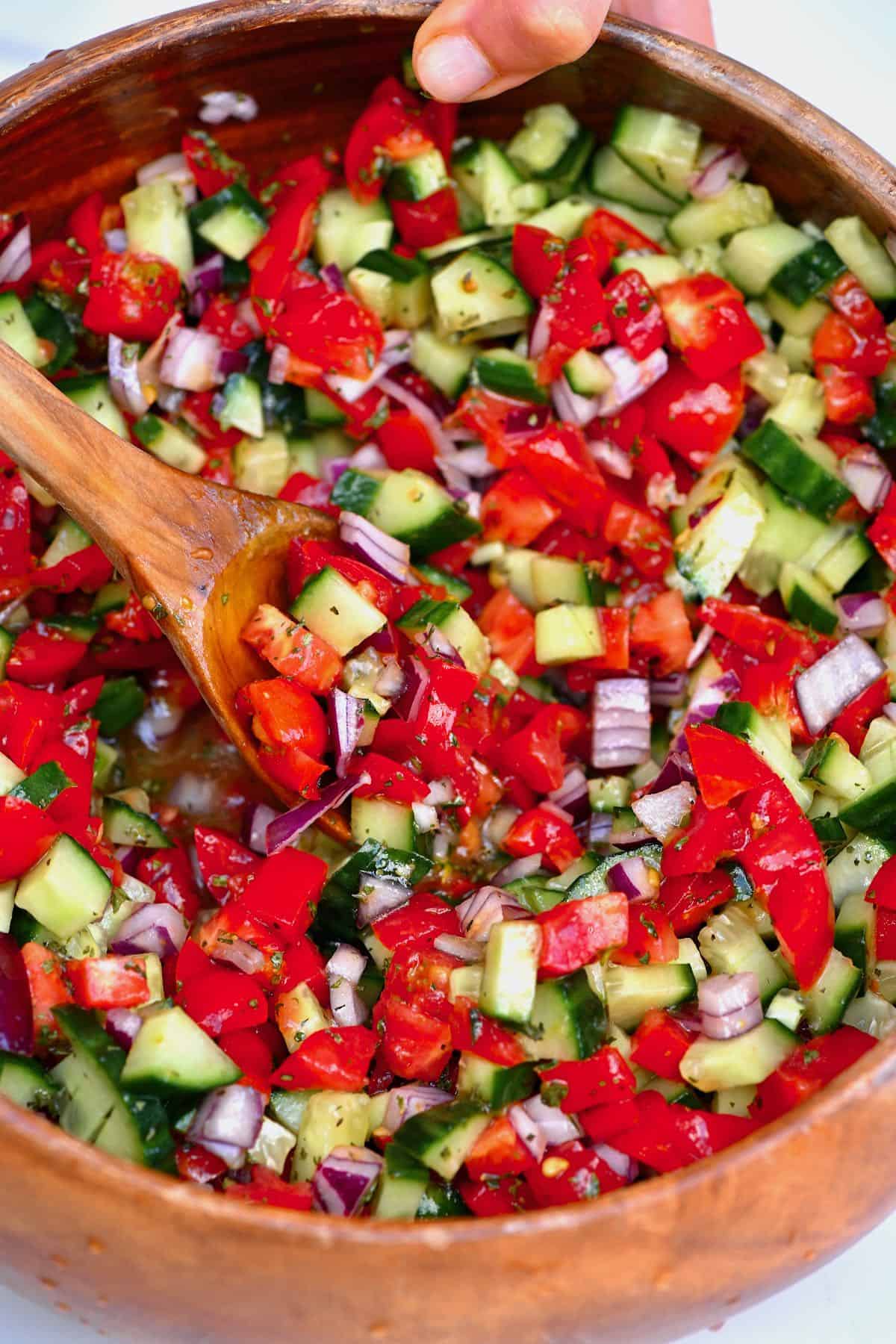 Mixing tomato cucumber salad
