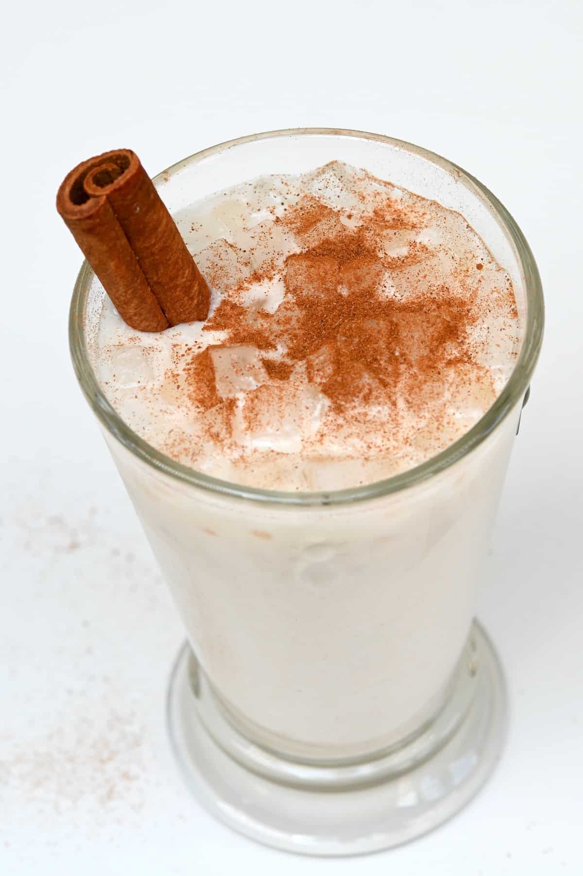 A glass with Mexican horchata topped with cinnamon powder