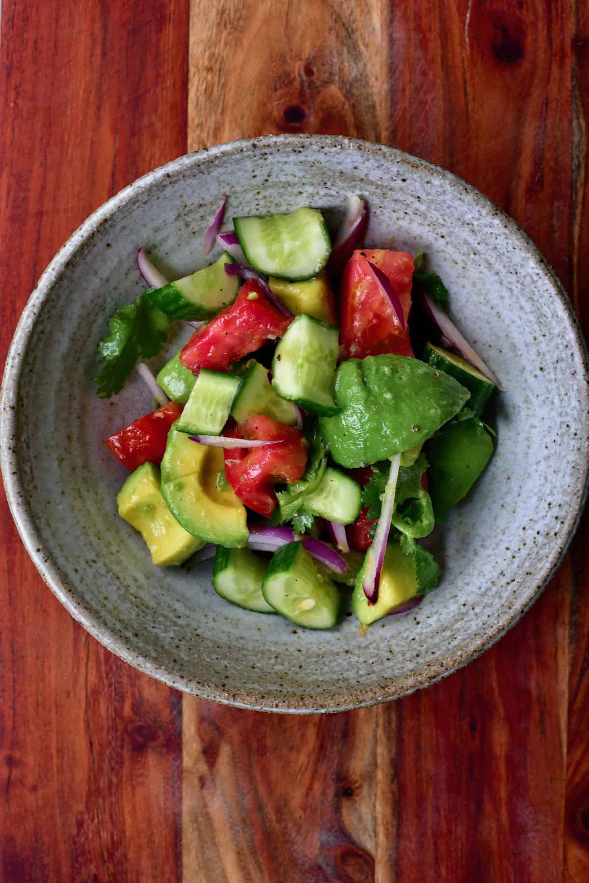 A serving of avocado cucumber tomato salad