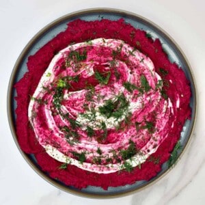 Beetroot hummus topped with whipped cheese and dill