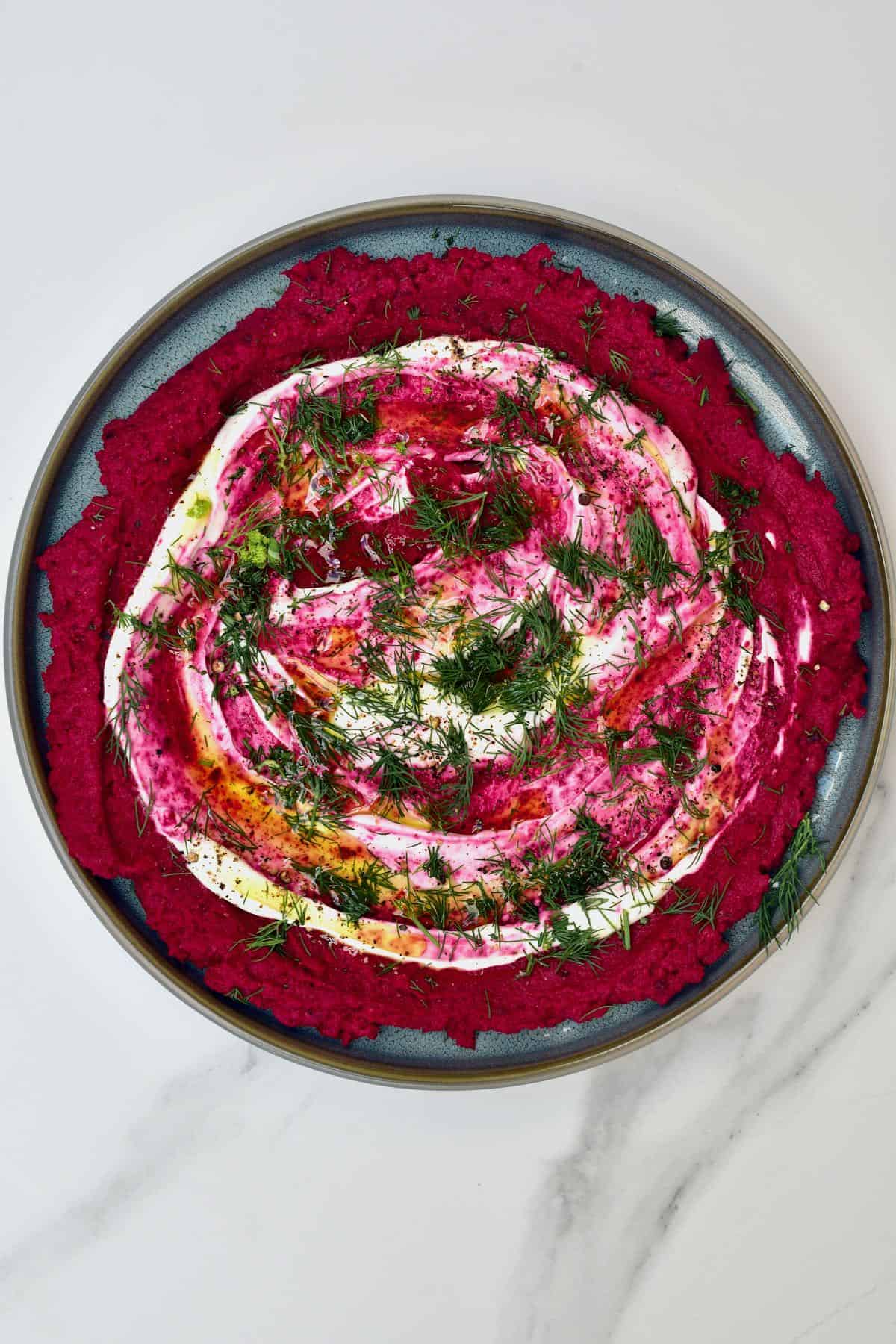 Beetroot hummus topped with dill whipped cheese and oil