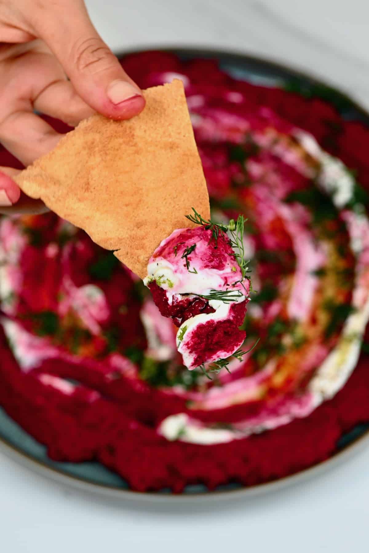 Chip topped with beetroot hummus