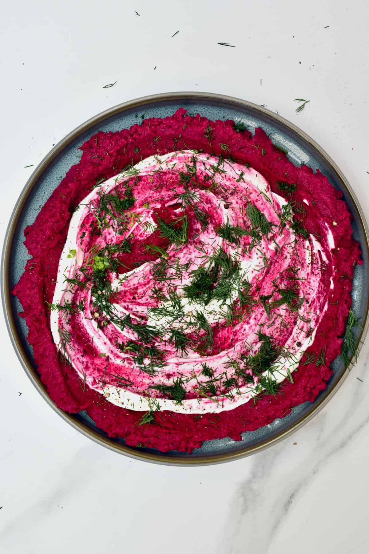 Beetroot hummus topped with dill and whipped cheese