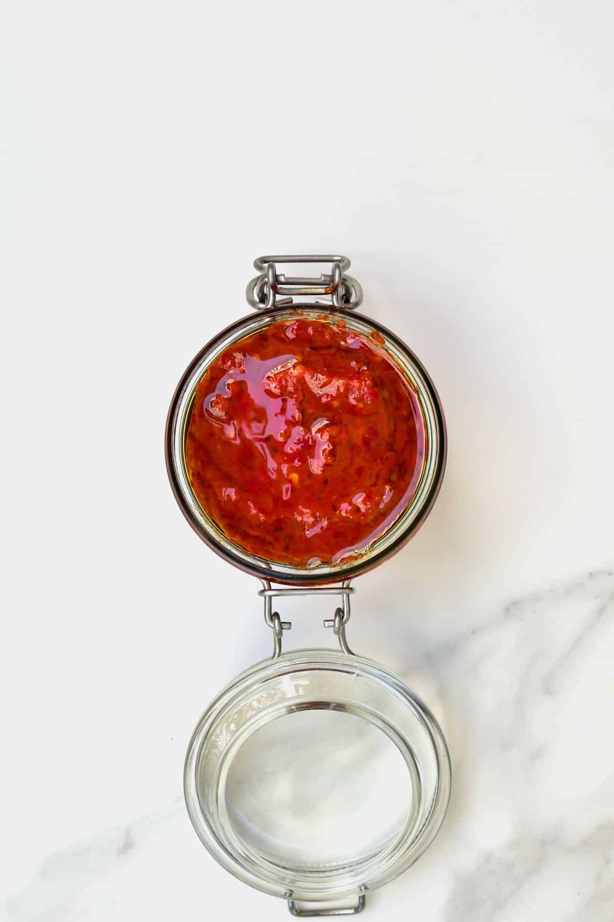 Harissa dip in a jar covered with a layer of oil