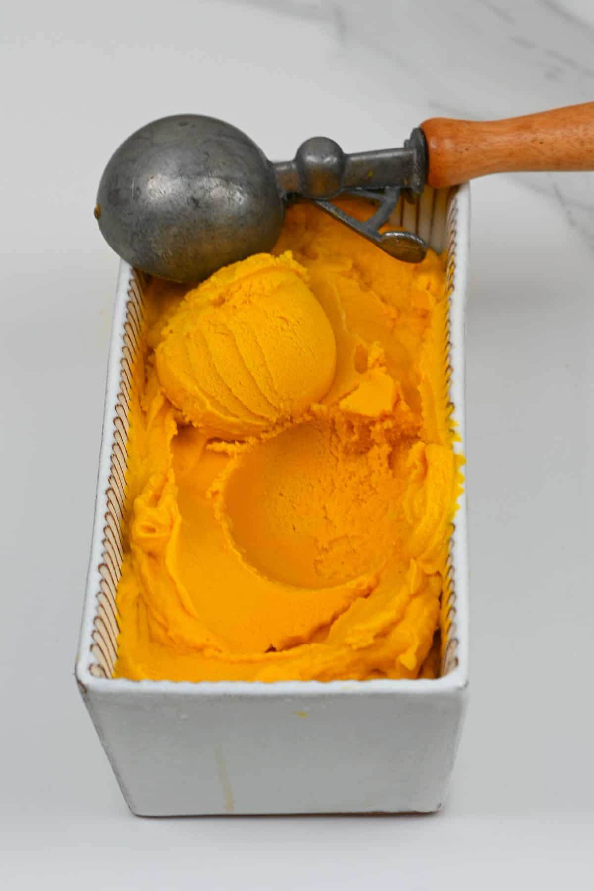 Scooping mango ice cream