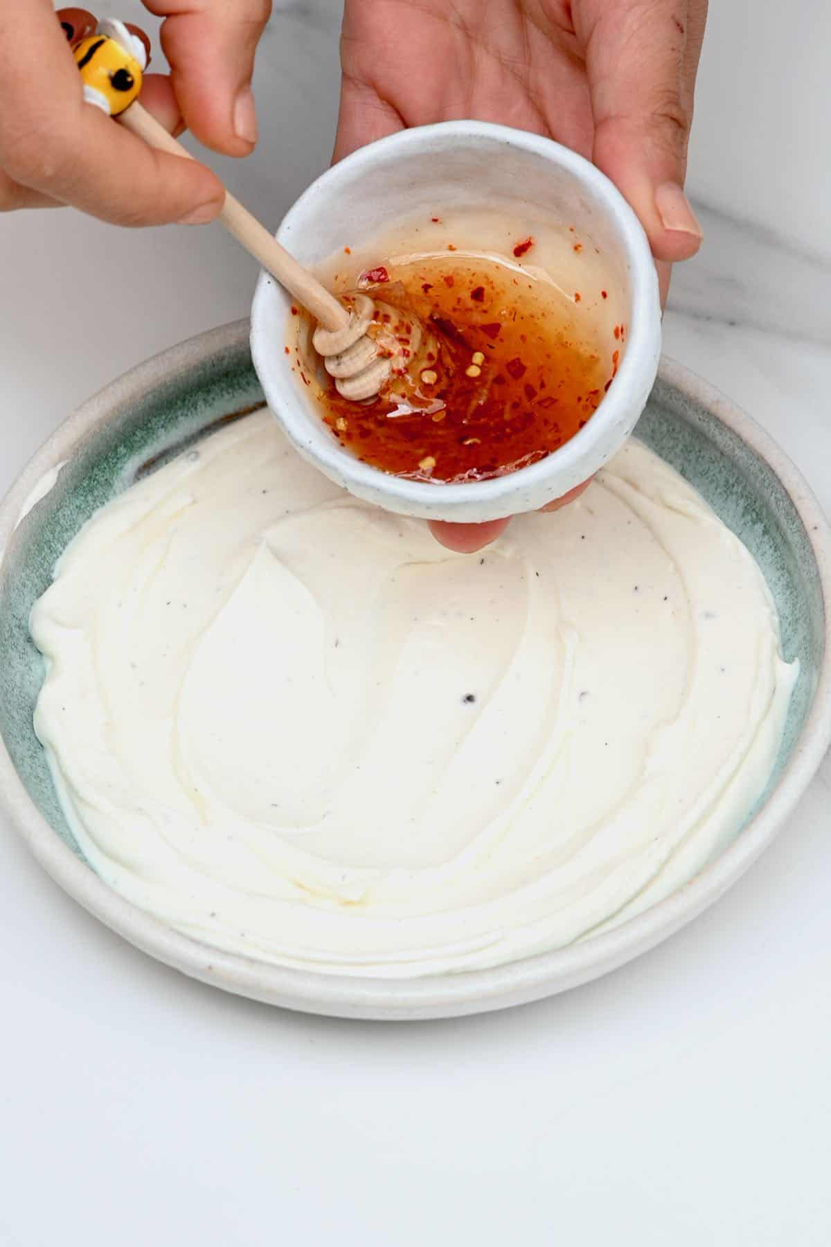 Pouring chili honey over whipped cheese