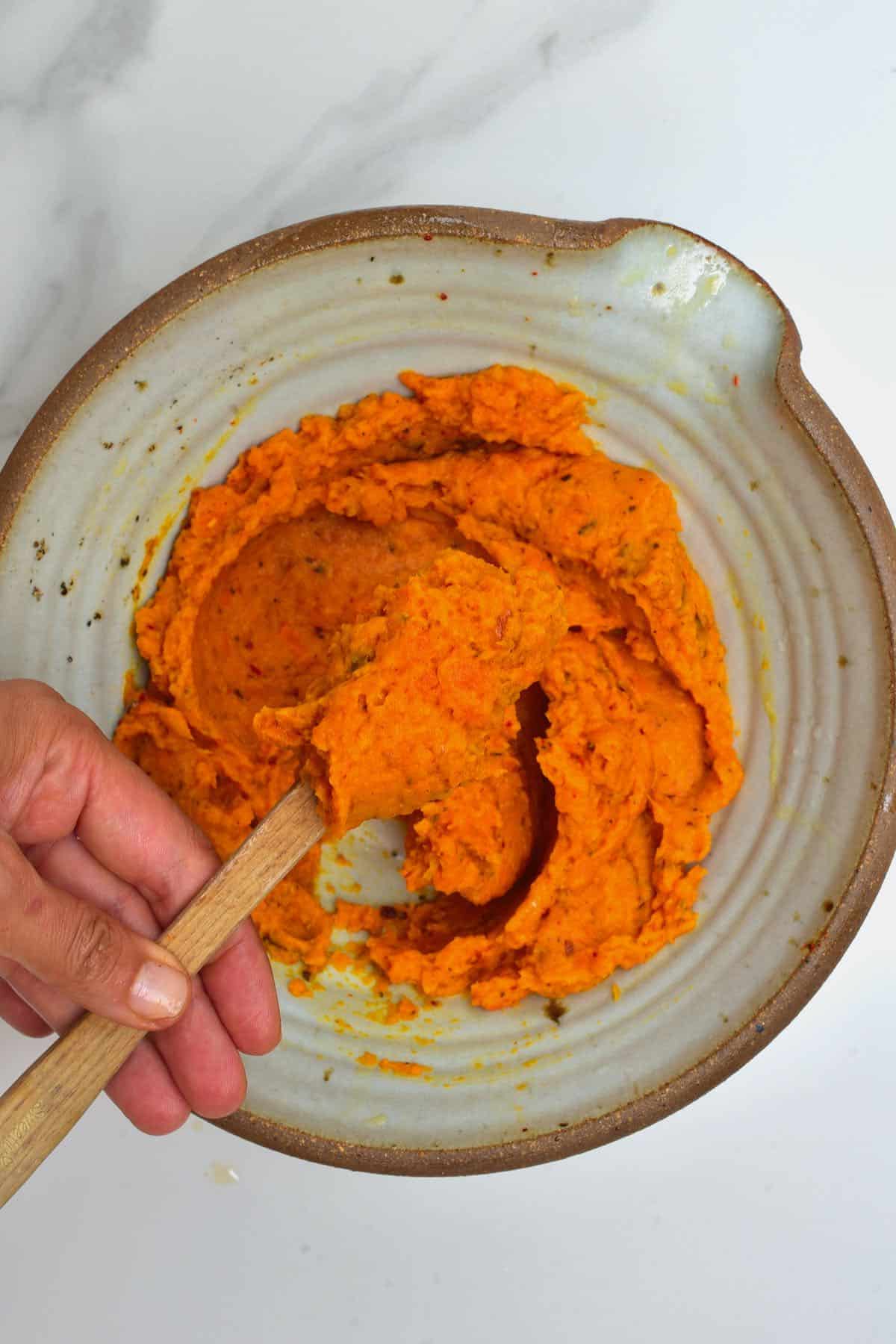 Roasted carrot dip in a bowl with a spoon