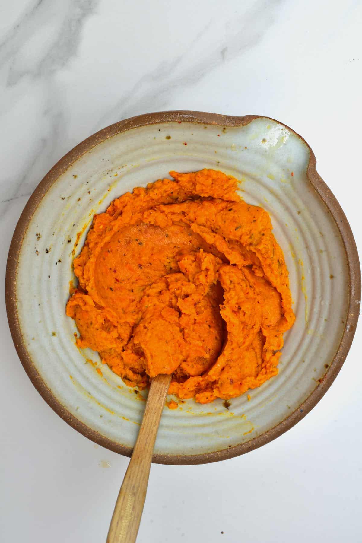 Roasted carrot dip in a bowl with a spoon