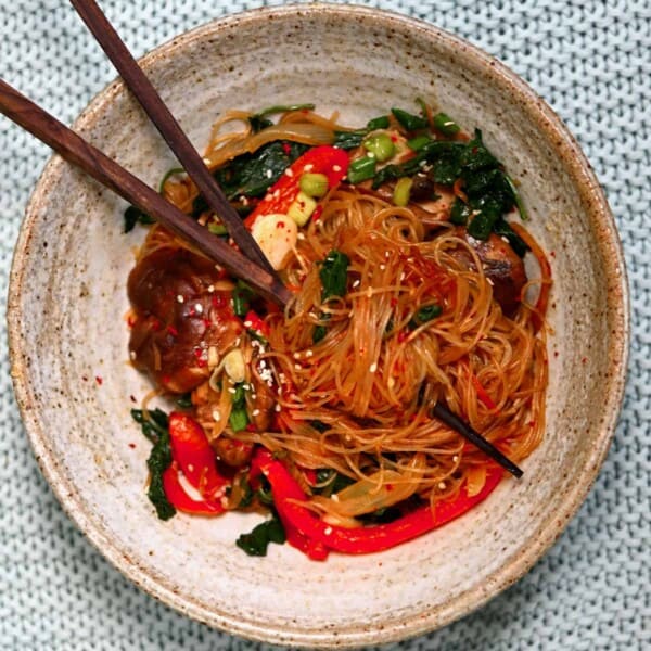 Japchae Korean glass noodles in a bowl with chopsticks