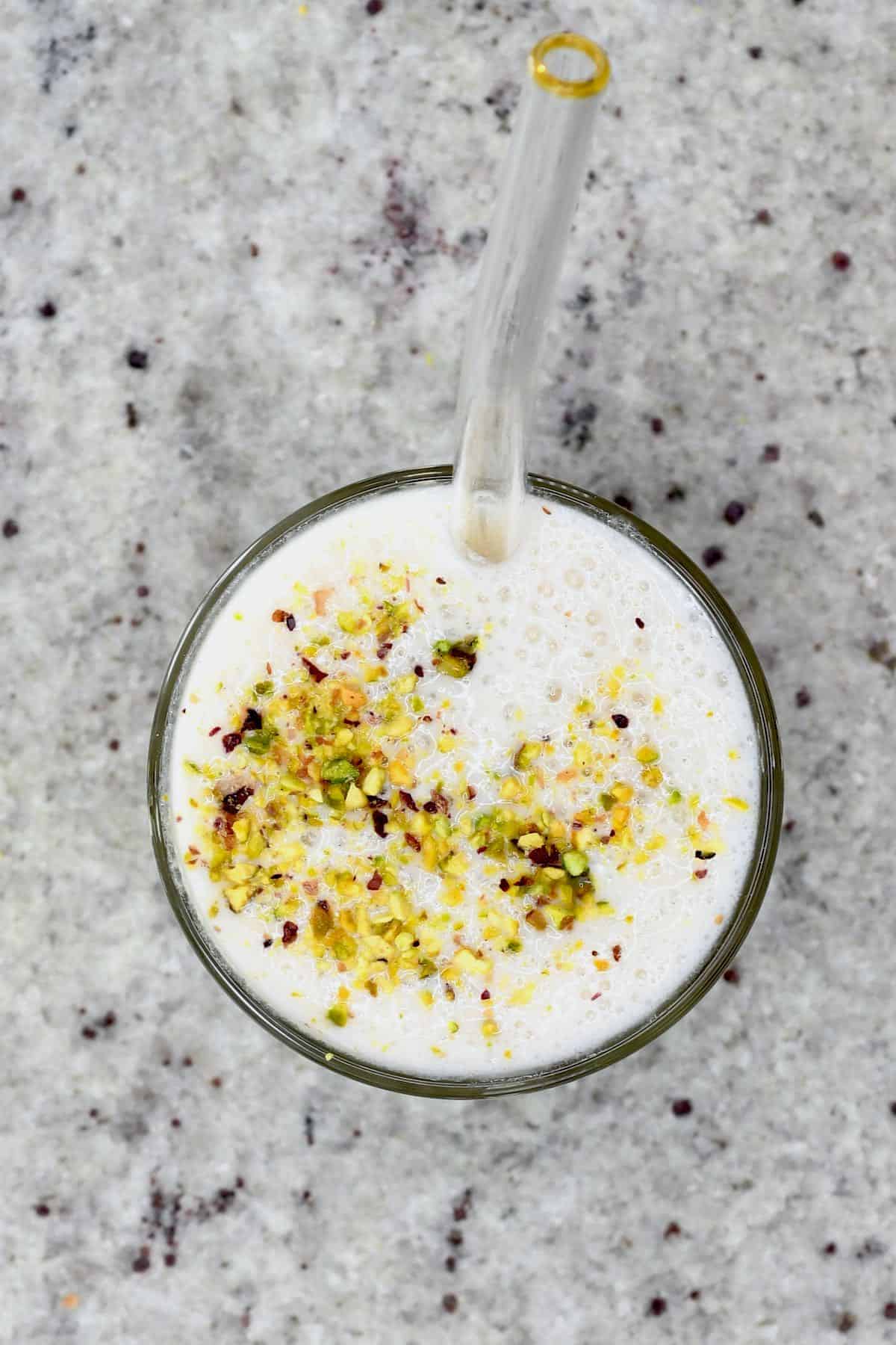 Top view of banana milkshake topped with pistachios