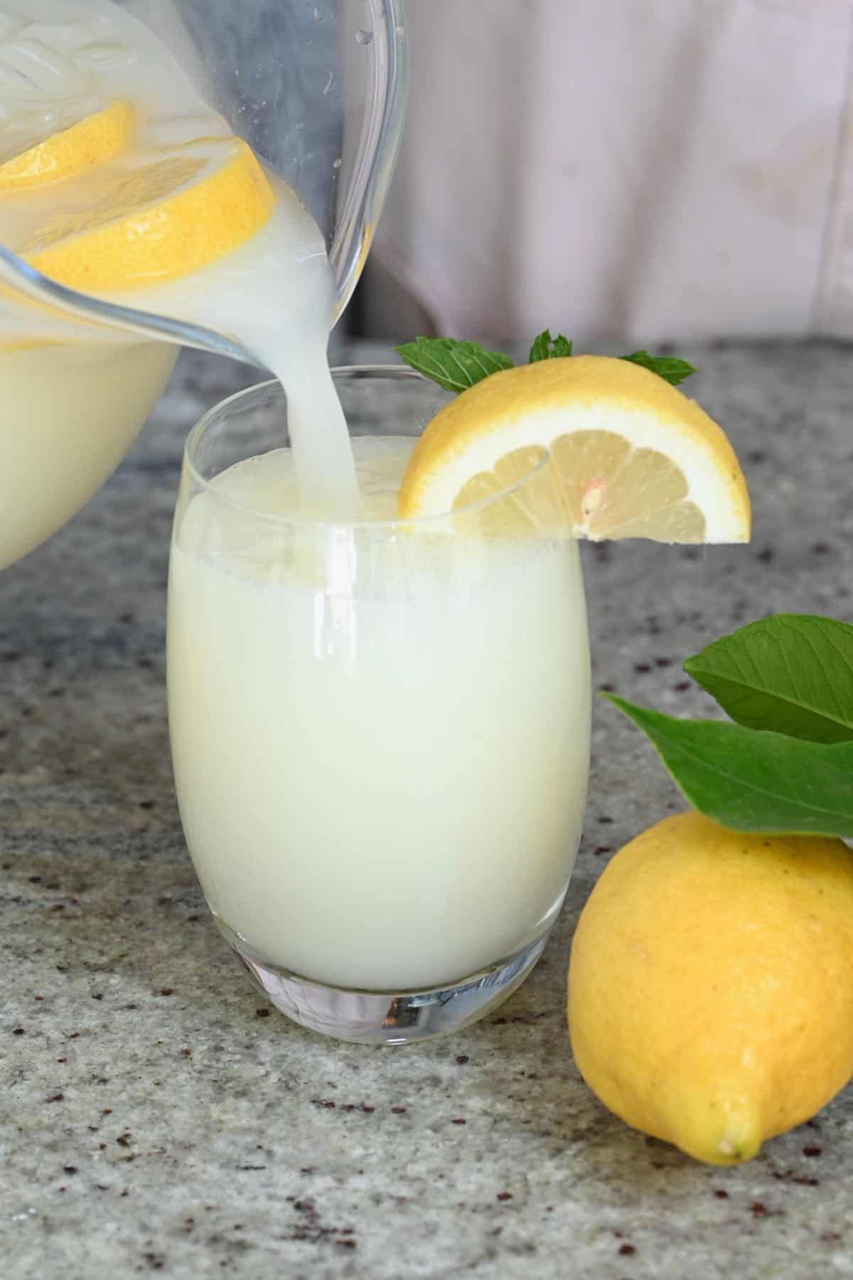 Pouring creamy lemonade in a glass