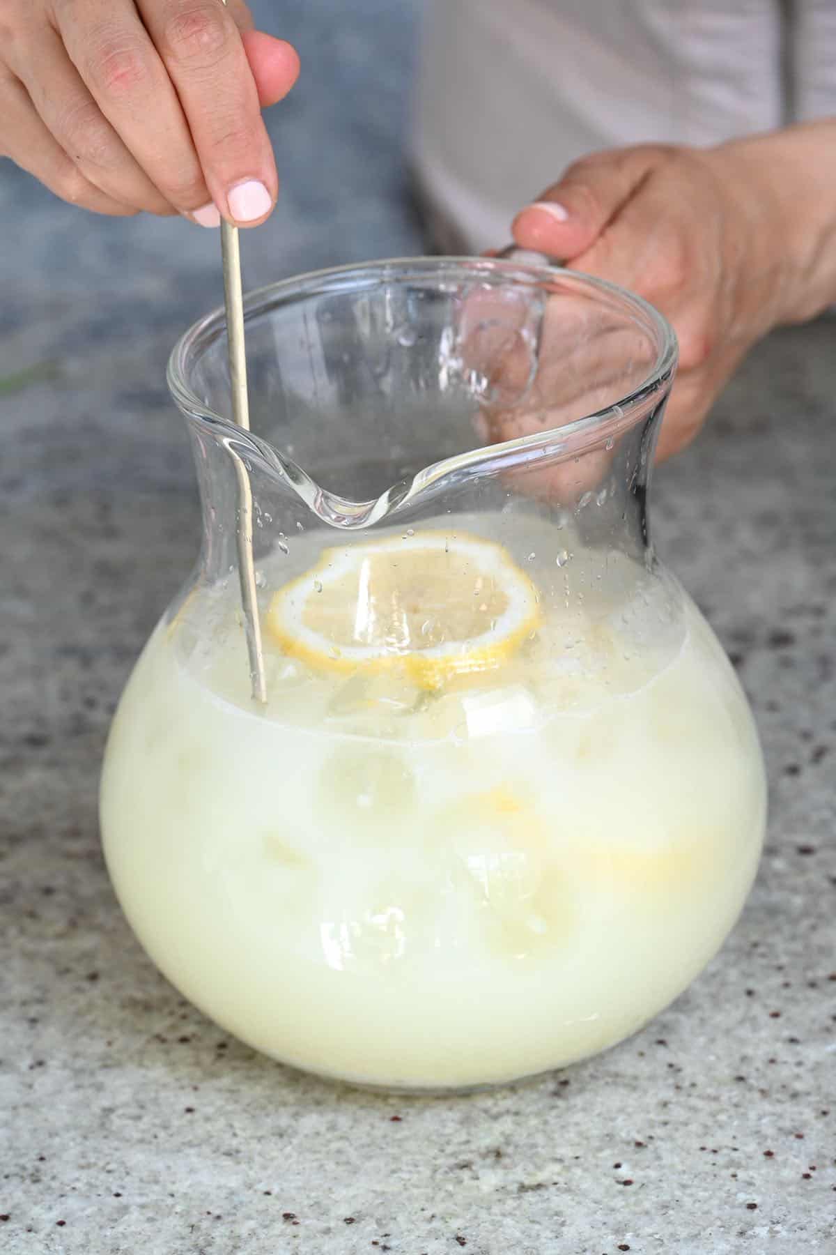 Stirring creamy lemonade in a jug