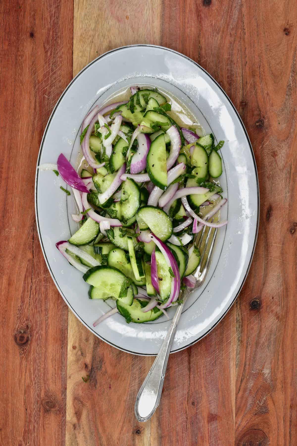Cucumber onion salad on a plate with a fork