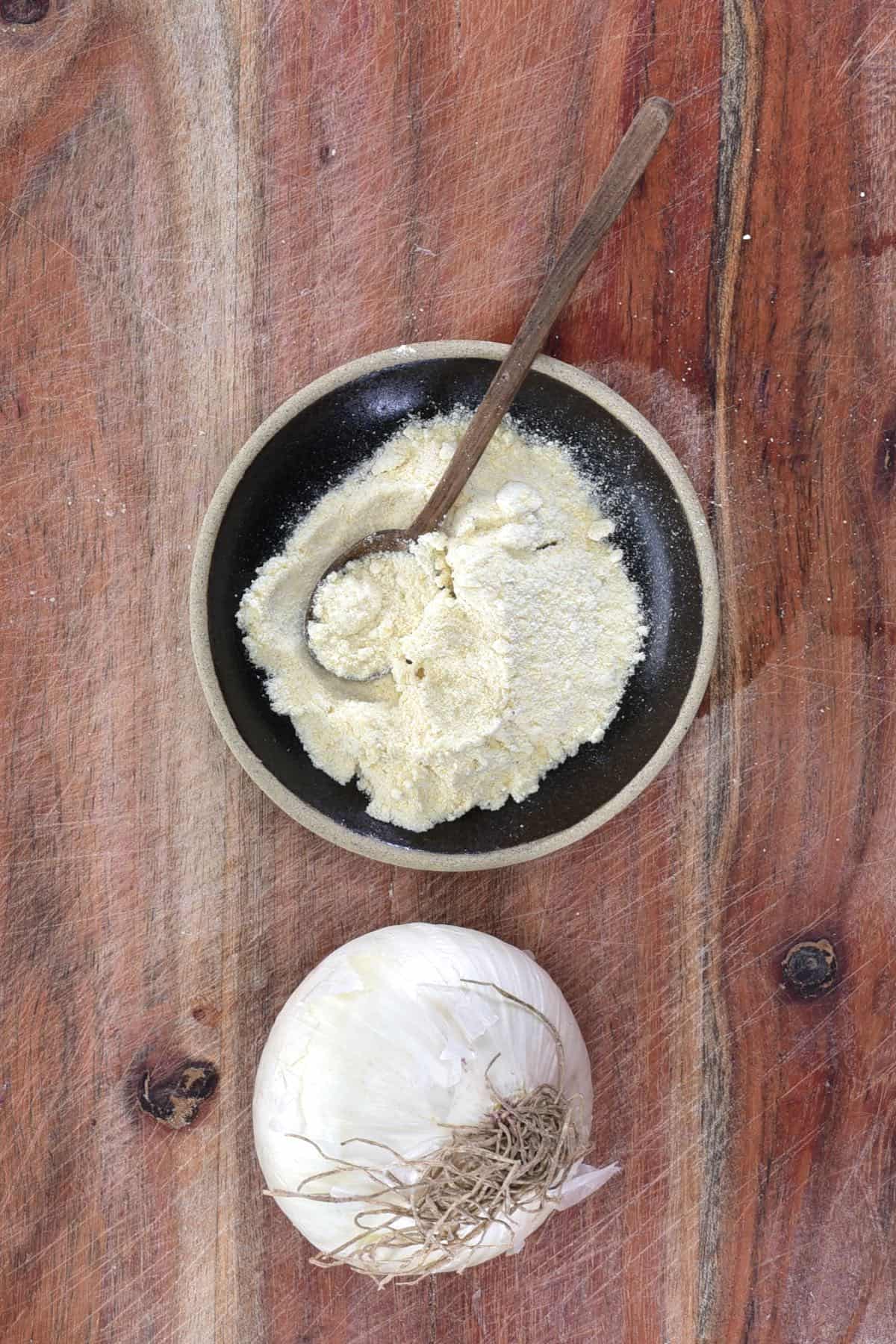Onion powder in a small bowl and an onion