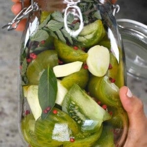 Pickled green tomatoes with garlic in a jar