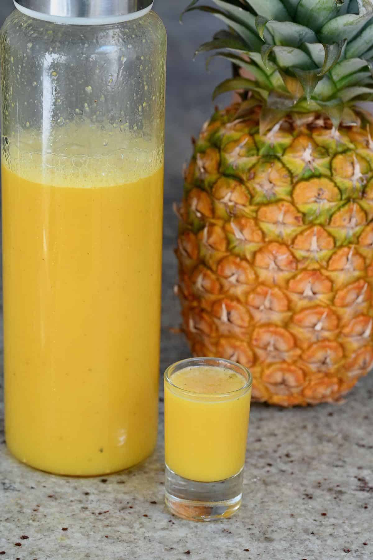 Pineapple ginger juice in a bottle and in a small glass
