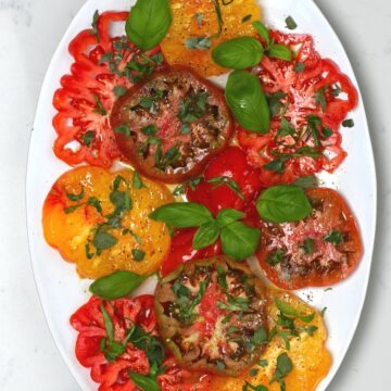 Simple tomato salad topped with basil in a plate