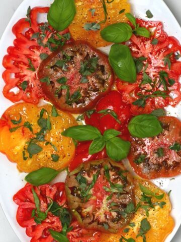 Simple tomato salad topped with basil in a plate