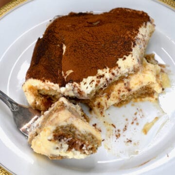 A serving of tiramisu on a plate with a fork