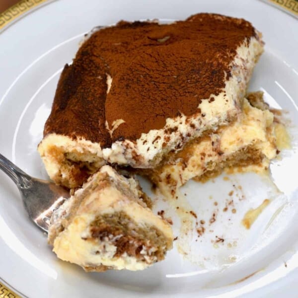 A serving of tiramisu on a plate with a fork
