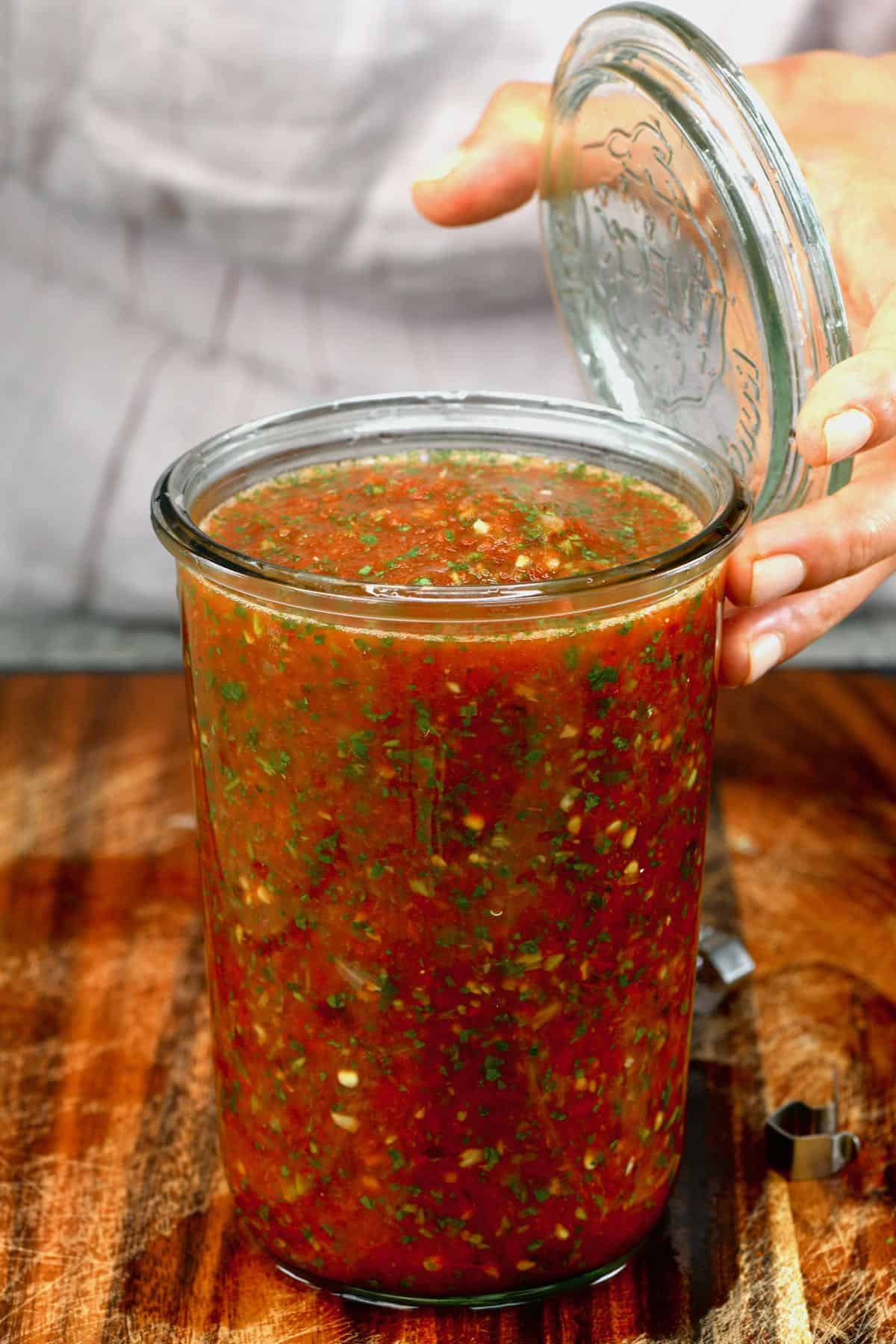 Open jar with roasted tomato salsa