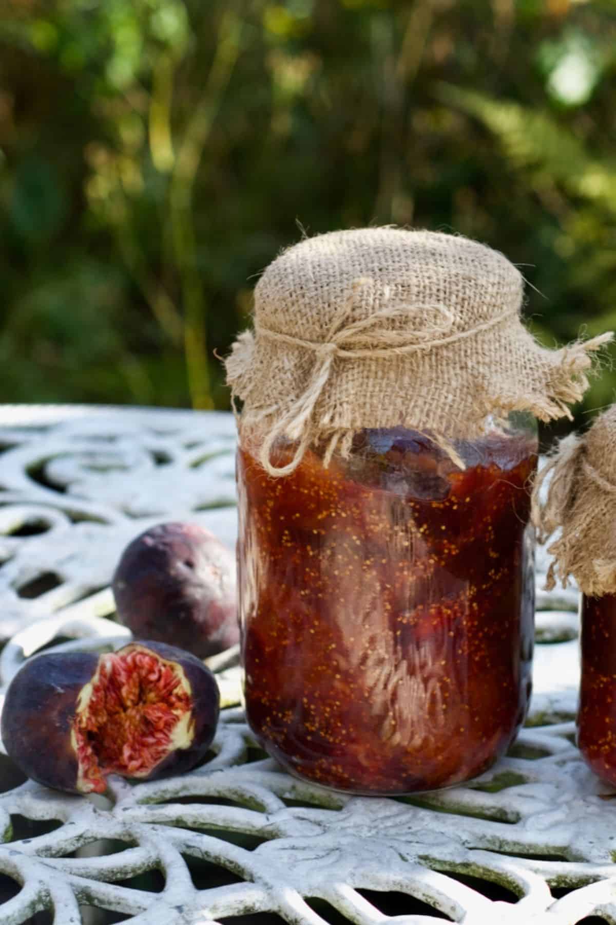 Homemade fig jam in a jar and two figs