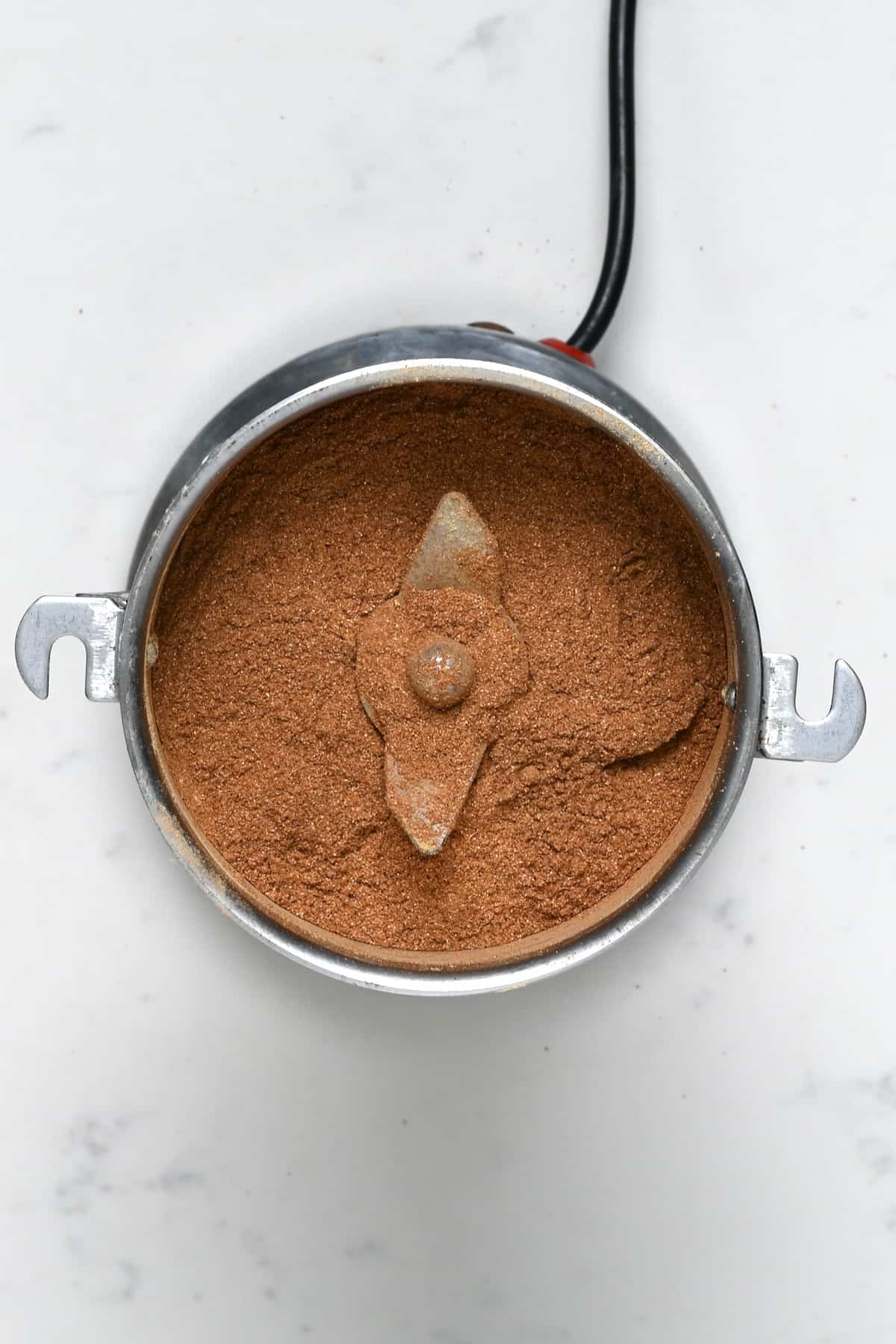 Homemade pumpkin spice mix in a grinder