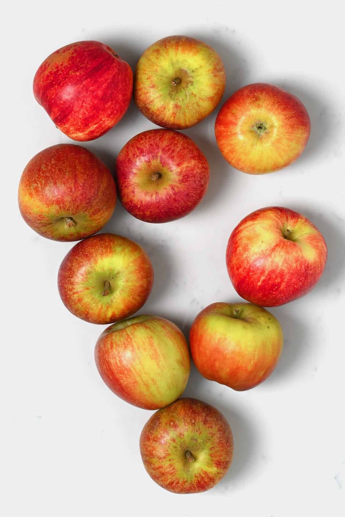 Ten red apples on a flat surface