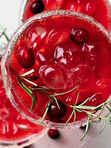 Cranberry juice served in a glass with rosemary