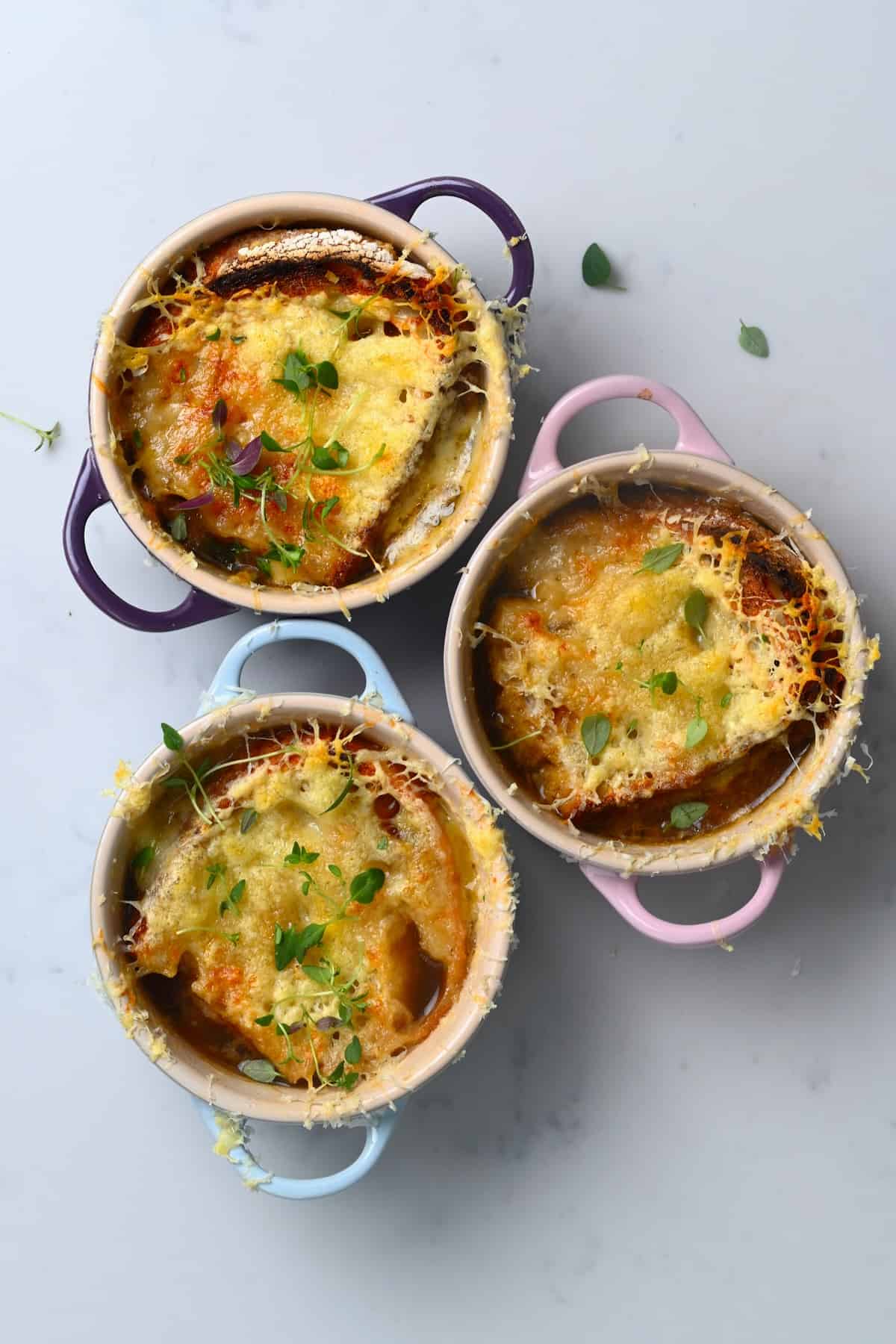 Three bowl with onion soup topped with melted cheese