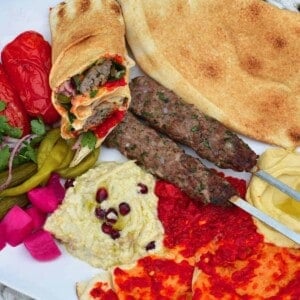 A platter with kofta skewers and dips