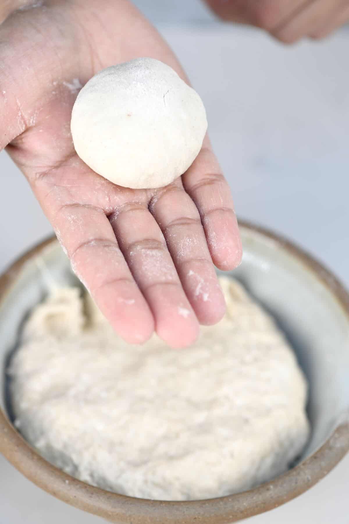 Shaping a dough ball for a potato roti recipe