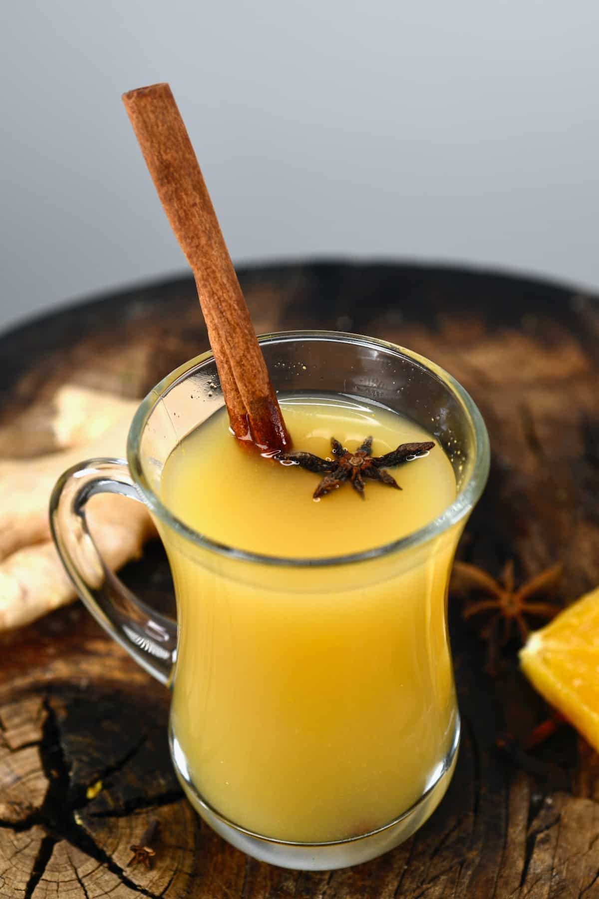 A glass with spiced apple cider (wassail) and cinnamon stick