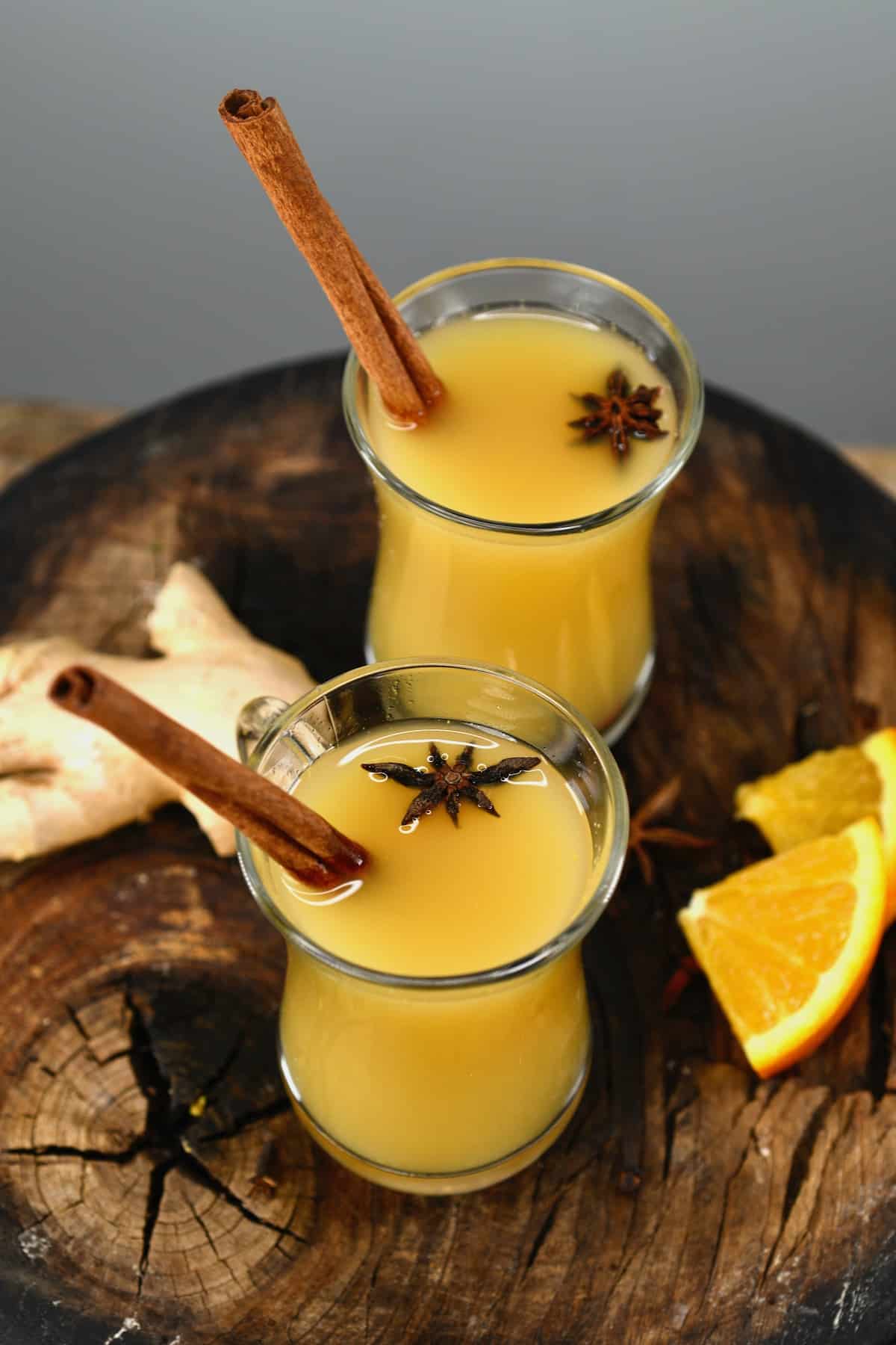 Two glasses with spiced apple cider (wassail) and cinnamon sticks