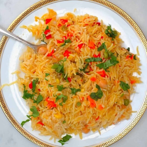 Vegetable rice served on a plate with a fork