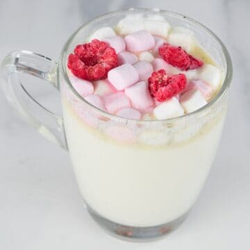 square photo of white hot chocolate in a glass mug