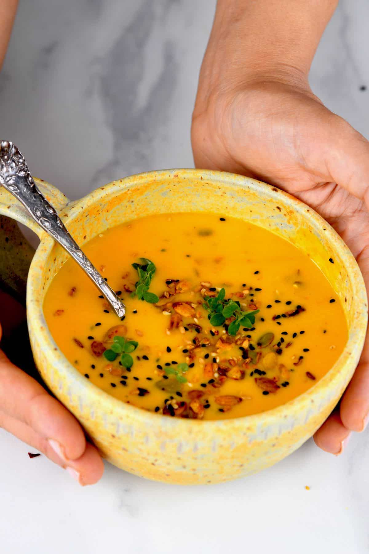 a small bowl of butternut squash soup with a spoon
