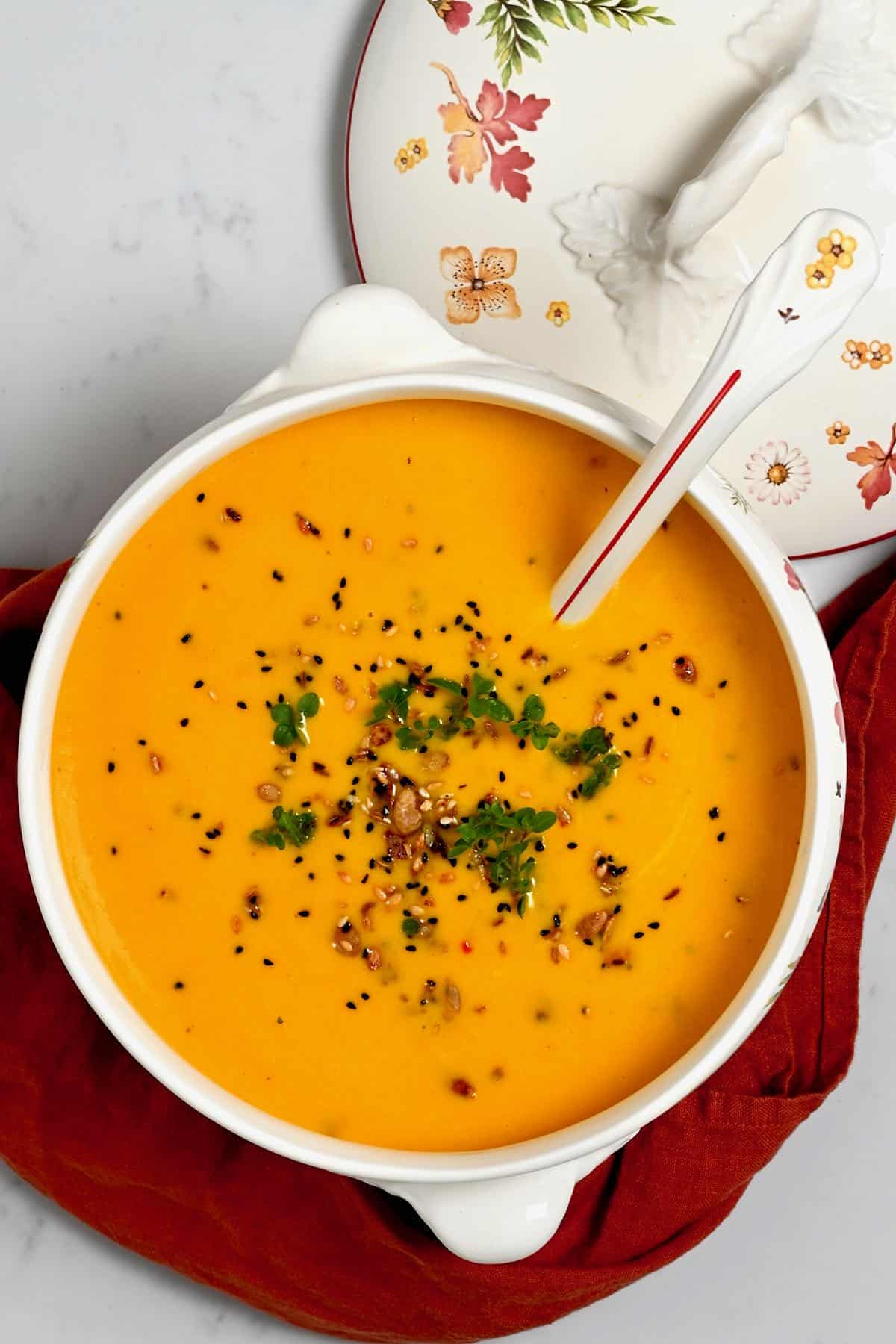 A large butternut squash soup bowl topped with seeds
