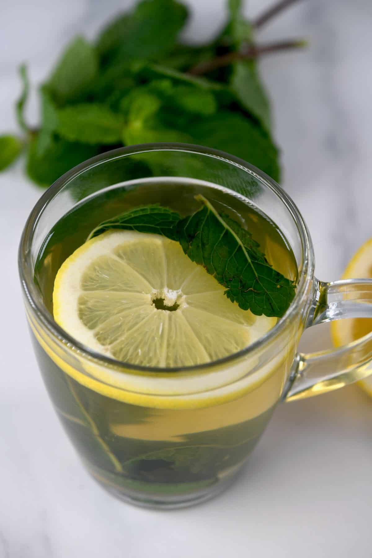 A glass with mint tea and lemon slice
