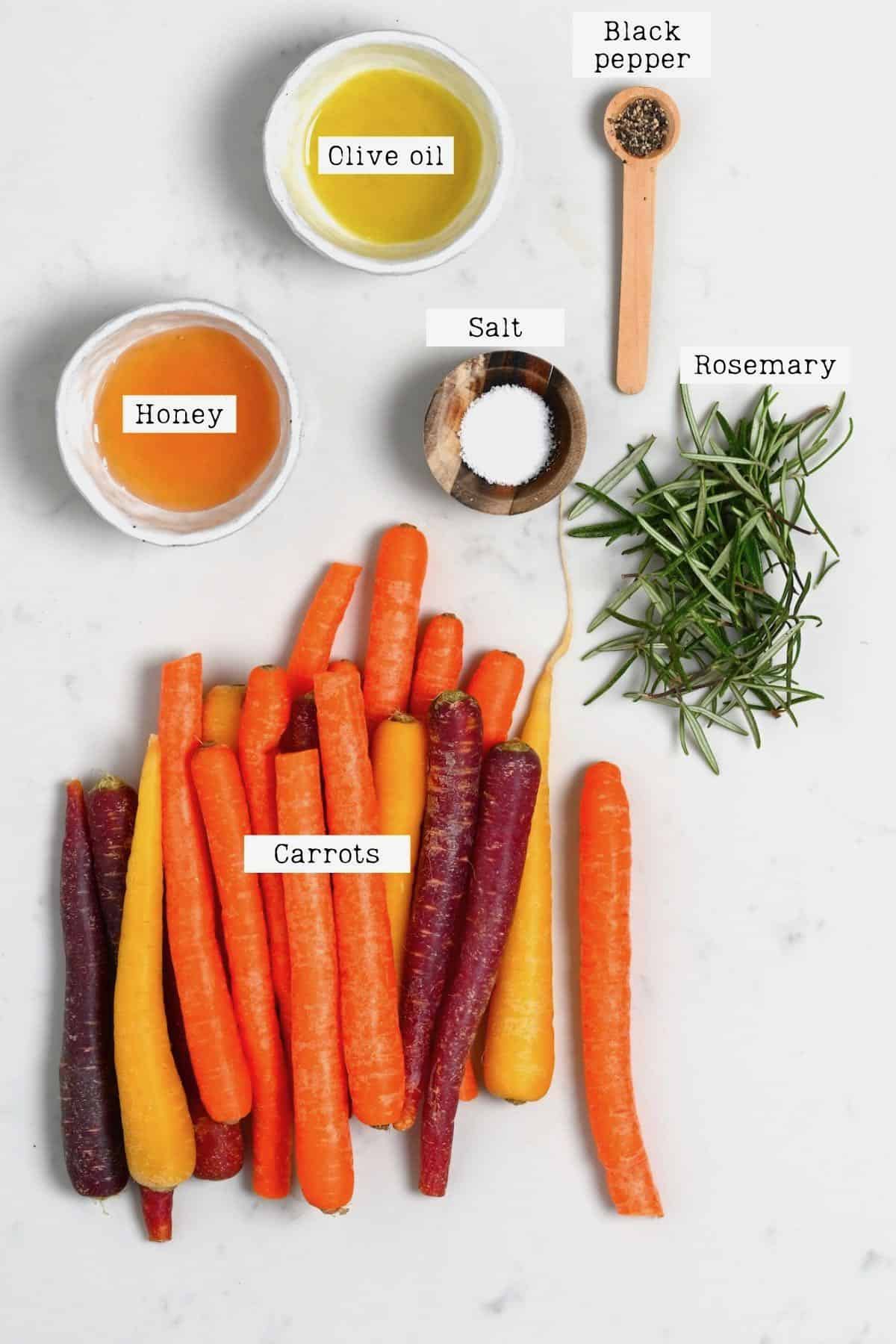 ingredients for roasted carrots placed on white marble