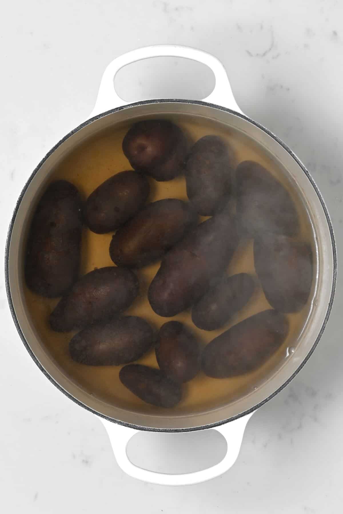 Boiled purple potatoes in a pot