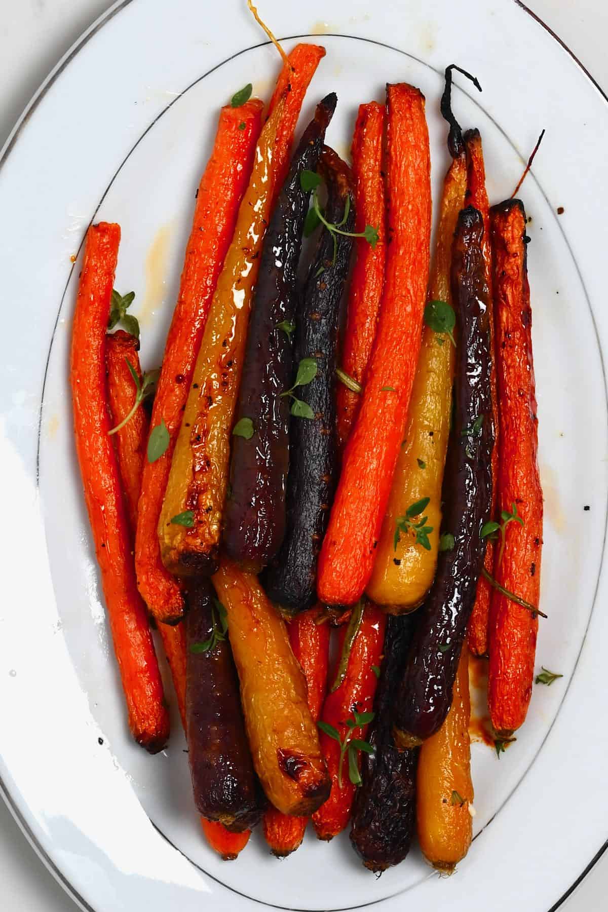 close up of roasted rainbow carrots on a white plate