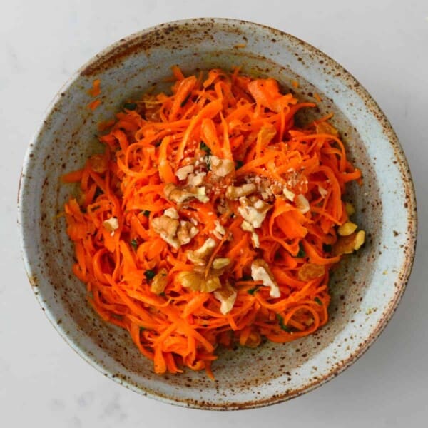A serving of carrot salad topped with walnuts