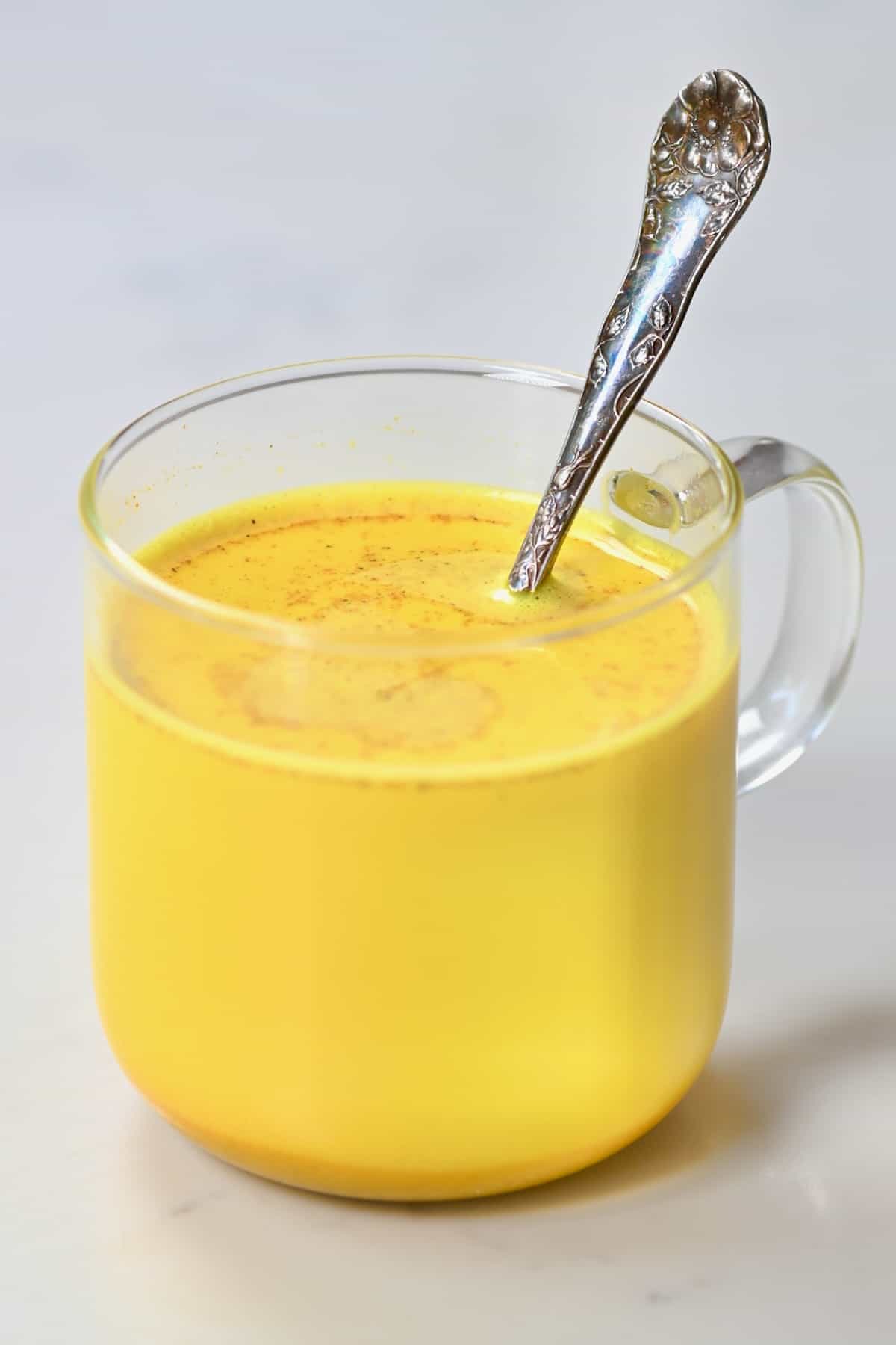 Golden milk in a glass cup