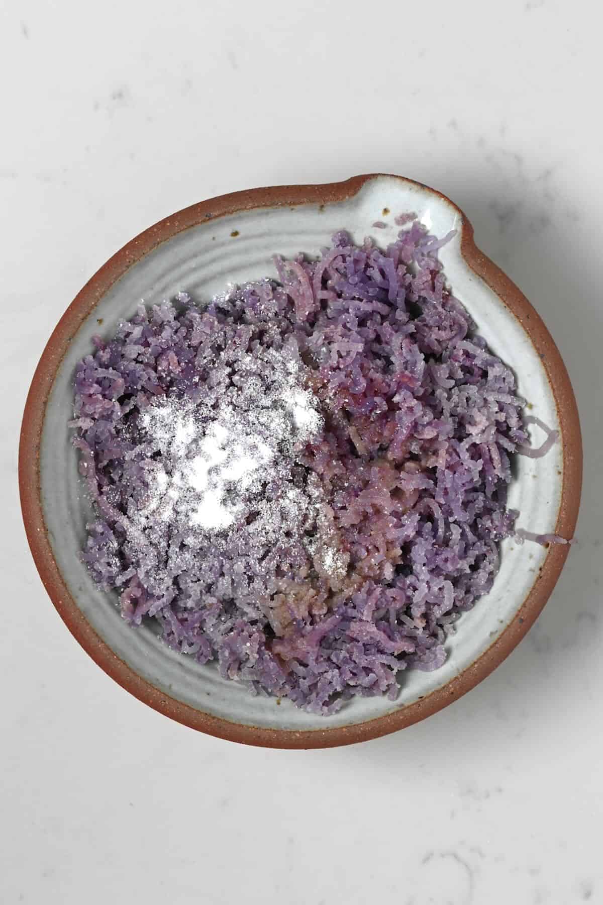 Adding seasoning to mashed purple potatoes