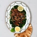 A serving plate with spinach and crispy onions and lemon - 16