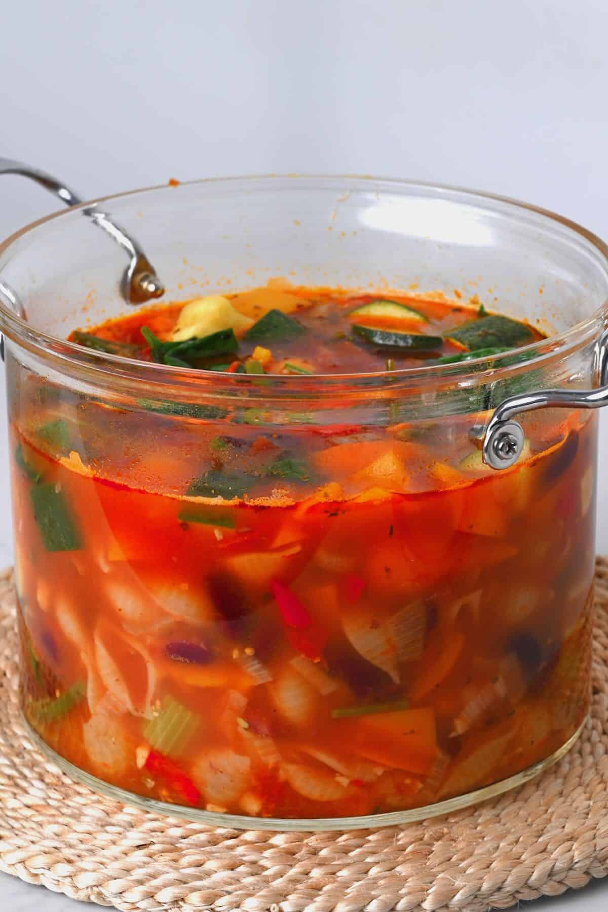 A large pot with vegetable pasta soup