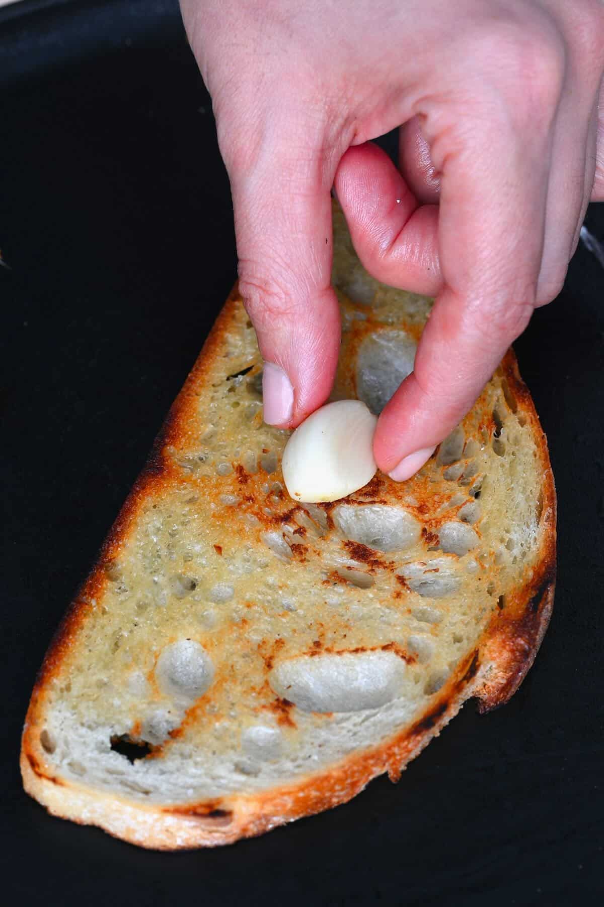 Rubbing a garlic clove on toasted bread