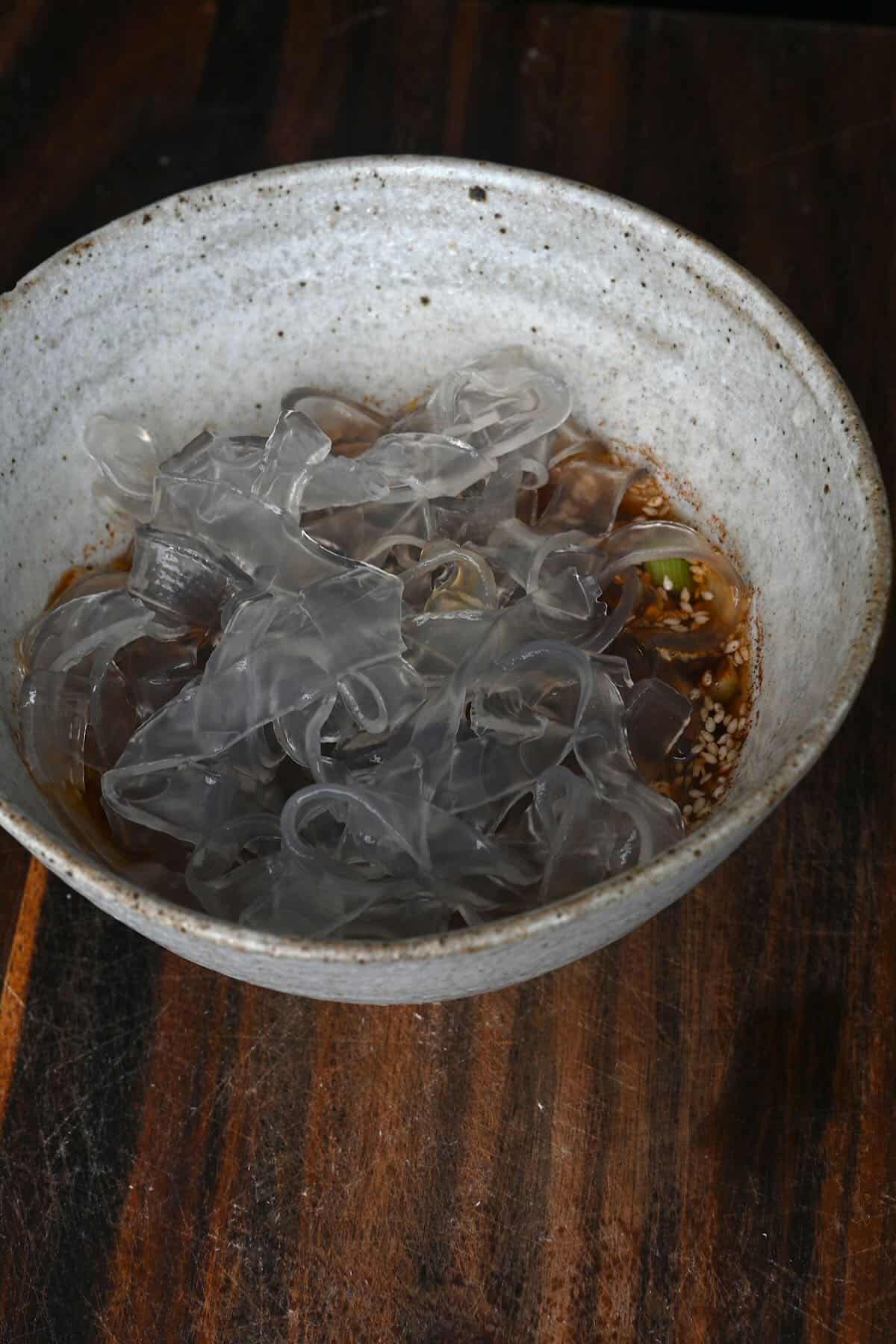 A bowl with cooked noodles over chili oil